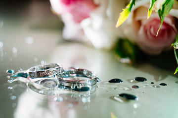 rings with drops of water on background of bouquet