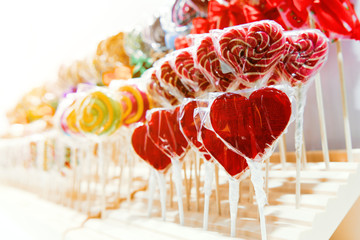 Red candies are arranged in even rows on a shop window.