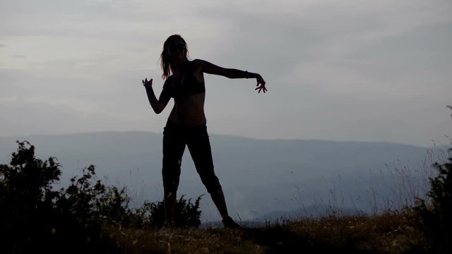 Girl dancing on top of tall mountain