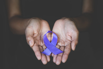 Hands holding Purple ribbons,  Pancreatic cancer, Epilepsy awareness, domestic violence awareness, Alzheimer disease, fibromyalgia awareness, world cancer day.