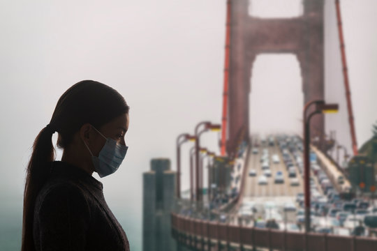 Coronavirus in California. Woman with surgical mask for corona virus covid-19 protection in San Francisco, USA, in front of Golden Gate Bridge. California, America.