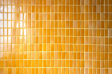 Sameless pattern of the yellow cement wall in the temple at Bangkok, Thailand. Yellow tiles lined up the wall.