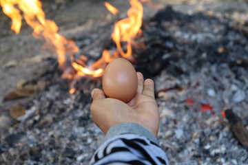 egg in hand fire background
