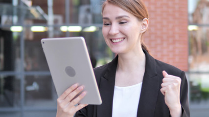 Young Businesswoman Cheering for Success on Tablet Outdoor