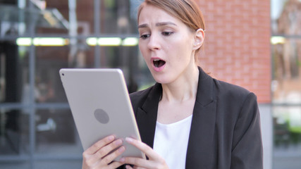 Outdoor young Businesswoman Upset by Loss on Tablet