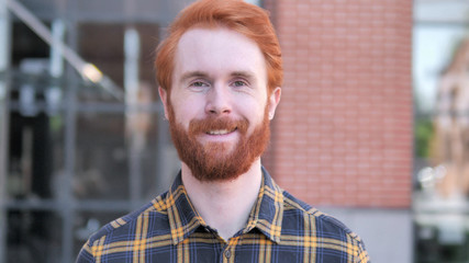 Outdoor Portrait of Smiling Redhead Beard Young Man