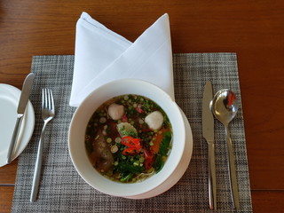 Top view of noddles, fish balls, vegetables and hot soup in a bowl.  Nutriuous food concept.
