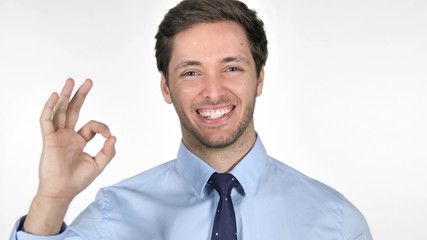 Gesture of  Okay by Young Businessman on White Background