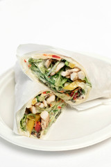 chicken salad wrap in white paper on studio background