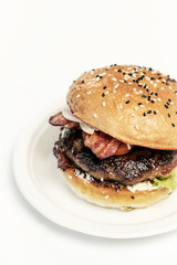 organic beef burger with bacon on white table
