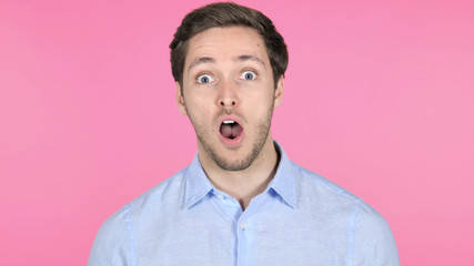 Surprised Young Man Wondering on Pink Background