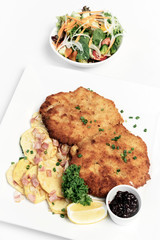 german breaded organic pork schnitzel with bacon fried potatoes