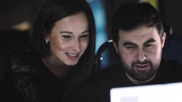 Two positive businessmen working at a laptop discussing the result of the work performed.