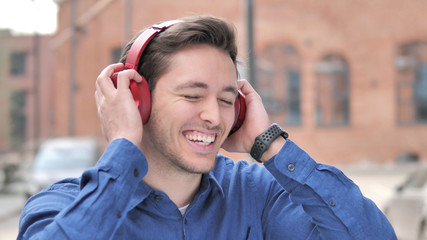 Dancing Young Man Listening Music on Red Headphones