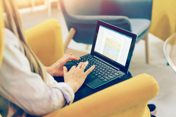 Close up of keyboard and laptop screen. Person is typing on a laptop. Business content. Modern technologies allow you to work and study remotely while staying at home via the Internet.
