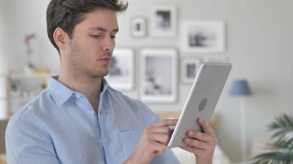 Handsome Young Man Browsing on Tablet