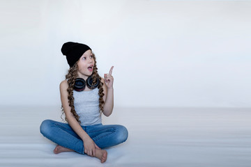 Fototapeta na wymiar girl in headphones shows a finger on the background