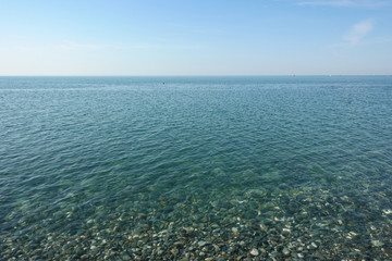 Sea view. Sea in calm weather. Clear water and pebble beach