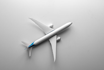 Travel concept with airplane toy over white background. Top view flat lay with copy space