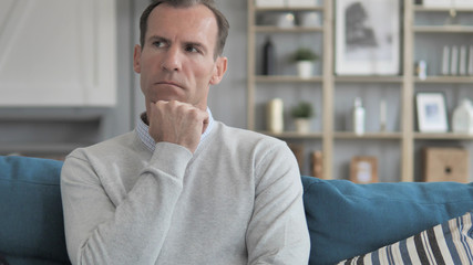 Pensive Creative Man Sitting on Couch and Lost in Thoughts