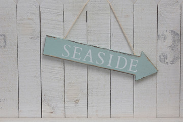 Hanging Seaside Sign Across White Wood
