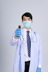 doctor physician practitioner measuring body temperature with infrared forehead thermometer gun