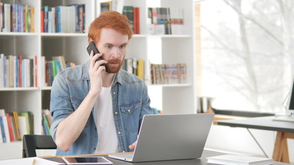 Young Casual Redhead Man Talking on Phone, Negotiating Contract