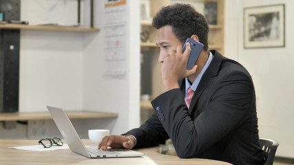 Fototapeta premium Young African Businessman Talking on Phone