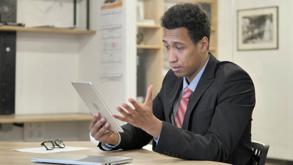 Fototapeta na wymiar Young African Businessman Browsing on Tablet, Watching Video