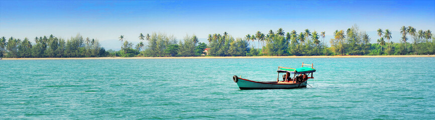 Fototapeta na wymiar Fishing boat on a background of palm trees