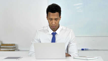 Afro-American Businessman Working On Laptop, Frontal View