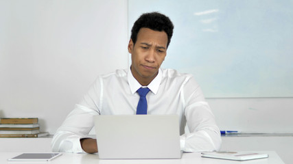 Thinking Afro-American Businessman Working on Laptop, Frontal View