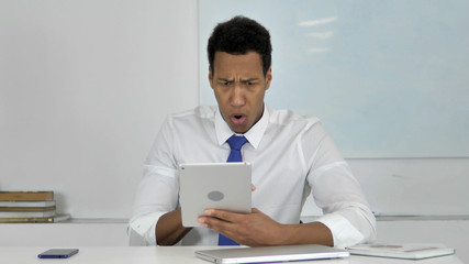 Fototapeta premium Afro-American Businessman Surprised by Results while Using Tablet