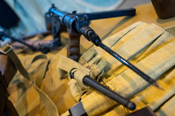 Antique assault rifle with a bayonet on the fabric. Militay blurred background.