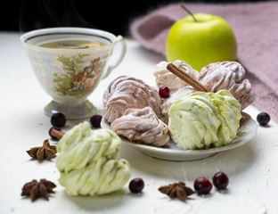 apple air marshmallow with cranberries, hot tea in the background, light background