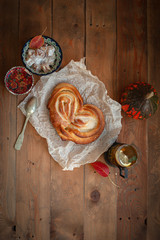 Freshly baked appetizing bun and tea on the board