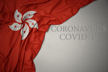 waving national flag of hong kong on a gray background with text coronavirus covid-19 . concept.