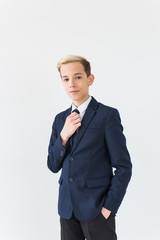 Portrait of stylish school boy teenager in white shirt and jacket against white background.