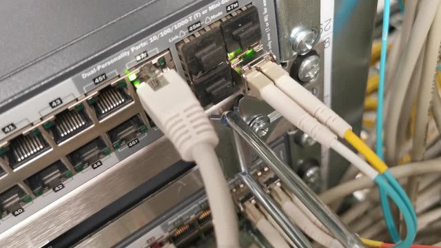 Netzwerk Switch verbunden mit Netzwerkkabel RJ45 Patchkabel und Glasfaserkabel in einem Rechenzentrum