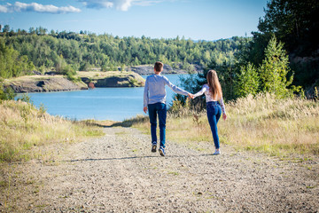 young couple walking in nature near lake