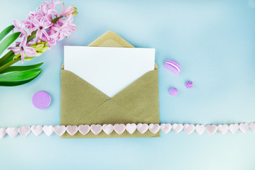 A wedding mock up concept. Wedding Invitation, envelopes, cards Papers on sky blue background with ribbon and hyacinth. Top view, flat lay, copy space. Wedding invitation or Valentine's day template.