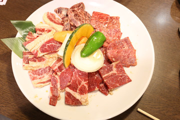 Raw Japanese beef on white dish and wood table