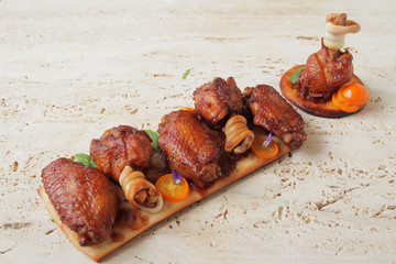  Juicy, fried chicken wings with spices and herbs, originally decorated and served on a marble table.