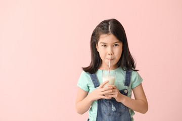 Cute Asian girl with milk on color background