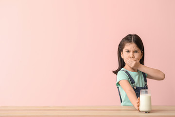 Cute Asian girl with dairy allergy on color background