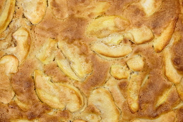 Apple pie, dessert from stewed fruits, closeup, texture, background, top view. Charlotte, homemade baking