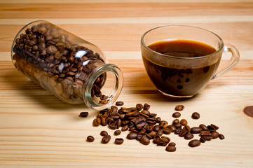 Coffee poured into a glass cup standing on a wooden surface. Background for coffee and coffee drinks.