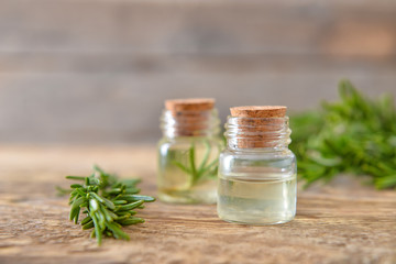 Bottles of rosemary essential oil on table