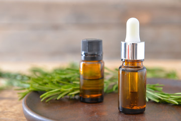Bottles of rosemary essential oil on table