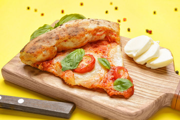 Board with slice of delicious pizza Margherita on color background